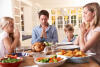 family-saying-prayer-eating-roast-dinner-18044146.jpg